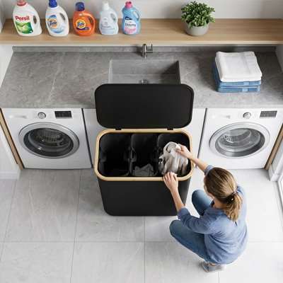 Panier à linge noir à 3 compartiments ouvert dans une buanderie 