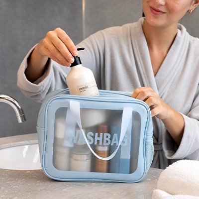 Trousse de toilette bleu ciel,face transparente, imperméable, inscription "WASHBAG", fermeture éclair, deux poignées latérales 